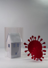 Representation of coronavirus COVID 19 made from paper trying to enter quarantined houses.  Quarantined people concept. Care and prevention concept. Viruses attacking people in quarantine.	