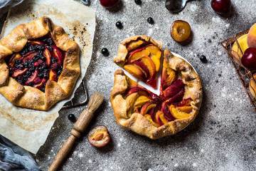 Summer galette with berries, raspberry, blueberry, blackberry, apple and crusty sugar vegetarian dough. Vegan food. Healthy food. Peach pie. Tart. Summer food, summer pie on parchment paper.