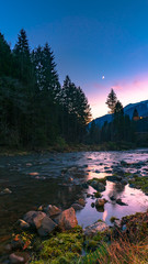 Gromo River at sunset and mountains on the background Lombardy, Italy.