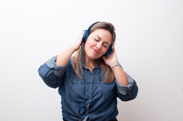 happy blonde woman listening to music with her hands on the headphone