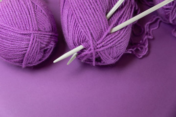 Background with knitting tools and accesories, colorful purple skein yarn, hobby concept, copyspace