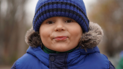 Portrait of little cute boy in a blue knitted hat