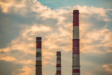 Old industrial pipes, the plant stopped its work, against the backdrop of the sunset sky