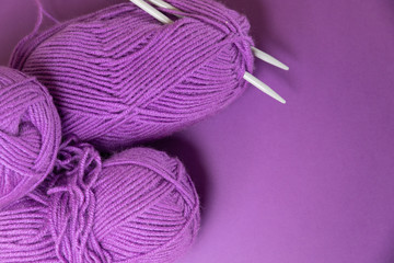 Background with knitting tools and accesories, colorful purple skein yarn, hobby concept, copyspace