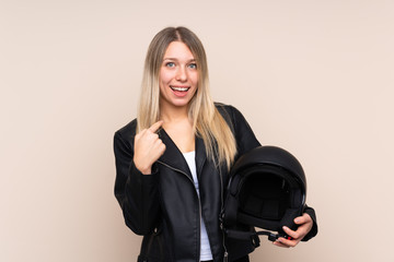 Young blonde woman with a motorcycle helmet over isolated background with surprise facial expression