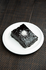 portioned brownie with chocolate sauce and coconut sprinkles