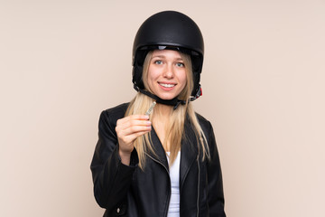 Young blonde woman with a motorcycle helmet over isolated background
