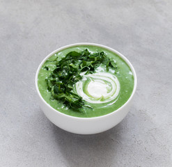 Green soup-puree ramson in a bowl on a light gray background