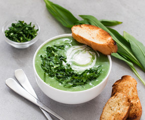 Cream soup ramson with croutons in a bowl on a light gray background