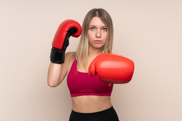 Young sport blonde woman over isolated background with boxing gloves