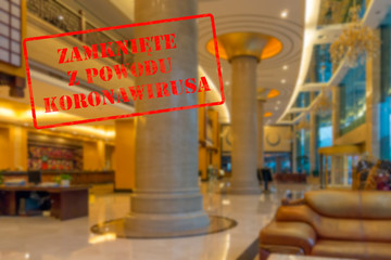 Defocused view of interior of an upmarket hotel reception, empty and closed with Polish notice Closed due to Coronavirus