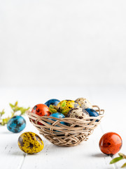 Colorful easter eggs. Yellow, blue, orange red quail eggs on concrete background. Shiny and bright easter decor. Copy space, place for text. Decoration concept.