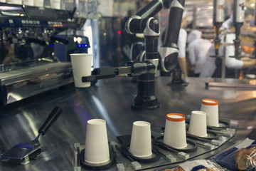 Robotic arm preparing coffee in coffee machine