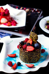 round chocolate cake topped with strawberry blackberry and raspberry