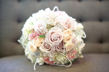 Romanatic pink, yellow and purple roses with white hydrangea bridal bouquet drapped in diamonds and pearls