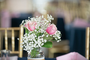 Romantic pink roses and babies breath flowers table centerpiece in glass mason jar with lace decoration