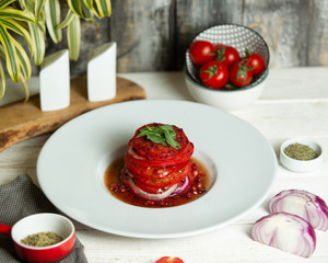 slices tomato salad with onion and pomegranate sauces
