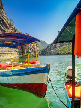 A boat with a canopy on the river. River boat. Pleasure boat on the river in Albania.