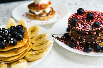 Pancakes with berries, chocolate, and banana. tasty breakfast. 
