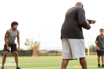 Obraz premium American Football coach training a young athlete.