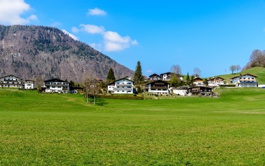 Obraz premium Houses by lake Thiersee nearby Kufstein. Blue sky, green field. Tyrol, Austria 