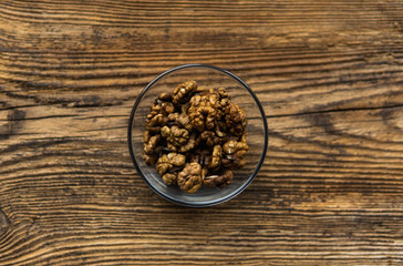 Walnut in a small plate on a vintage wooden table as a background. Walnuts is a healthy vegetarian protein nutritious food. Natural nuts snacks.