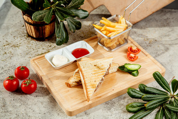 toast with meat served with french fries and sauces