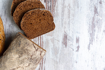 Top view of fresh healthy multi-grain seedy and rye bread on rustic wooden table. Assorted loaves of bread close-up, whole and sliced. Background, idea, concept, copy space