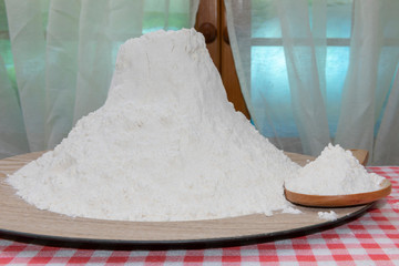 Plato con mucha harina y cuchara de madera.