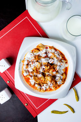 turkish dumplings manti garnished with tomato sauce and yogurt