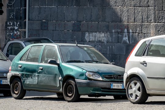 The damaged small French Citroen Saxo hatchback after a car accident because of typical careless driving and parking in Southern European countries
