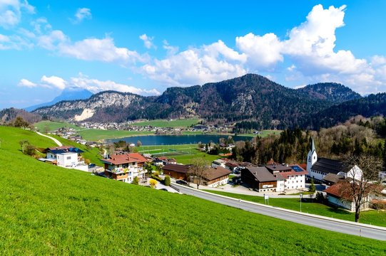 Beautiful view on lake Thiersee, alps Mountains, houses, church, blue sky, green fields. Austria, Tyrol. Border with Bavaria, Germany