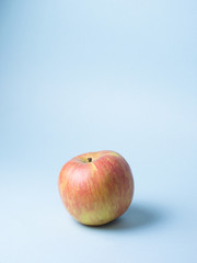 tower from yellow and red apples on cold blue background