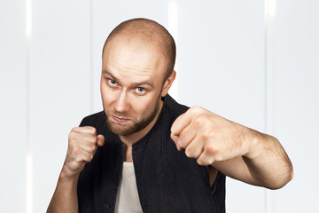 bald evil guy criminal extortionist preparing for a fight and swinging his fist