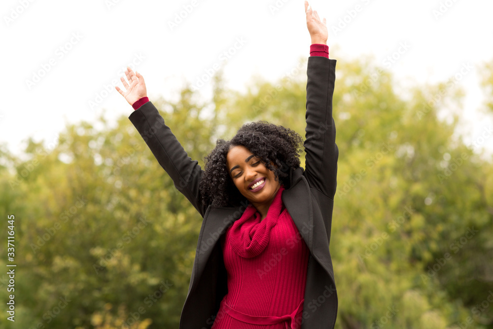 Wall mural African American woman smiling with open arms.