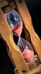 an old hourglass at an angle. a lot of black negative space