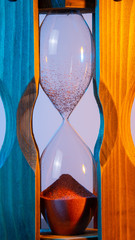 close-up of wooden vessels of the hourglass. time is up. blue-red illumination on both sides
