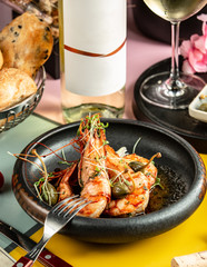 a bowl of fried king prawns garnished with herbs