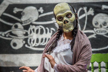 mujer con mascara de calavera, en una pbra de teatro por el día de muertos