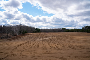 Fototapeta na wymiar Image of Muddy Fields with Cloudy Blue Sky Background