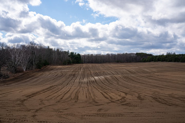 Fototapeta na wymiar Image of Muddy Fields with Cloudy Blue Sky Background
