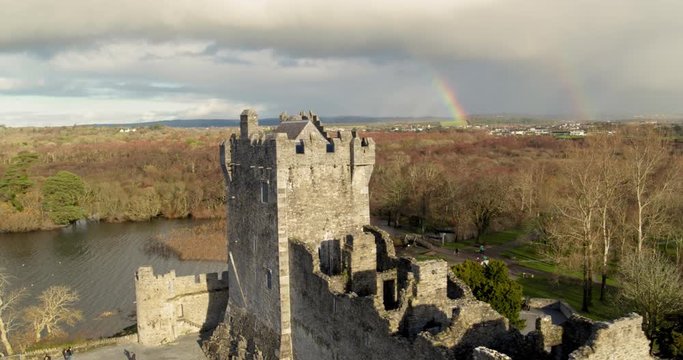 Double rainbow behind and old Irish castle. Forrest and hills.Stunning aerial shot.