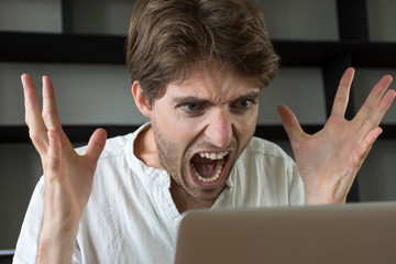 Homme furieux qui crie sur son ordinateur