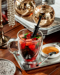 a glass cup of berry cocktail with strawberry raspberry and mint