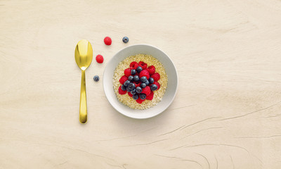 Oatmeal porridge in bowl topped with fresh berries.