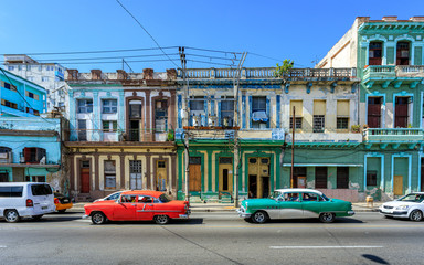 Naklejka na ściany i meble Havana Cuba Typical collection of old vintage colored houses in downton with american classic cars.