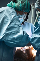 In the hospital operating room. An international team of professional surgeons and assistants works in a modern operating room. Professional doctors celebrate successfully saved lives.