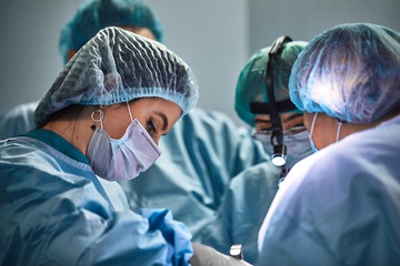In the hospital operating room. An international team of professional surgeons and assistants works...