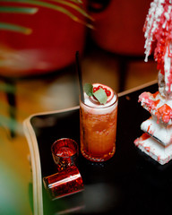 a glass of cranberry juice garnished with passion fruit © Kamran