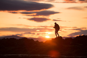 silhouette of a man on a rock at sunset, iceland